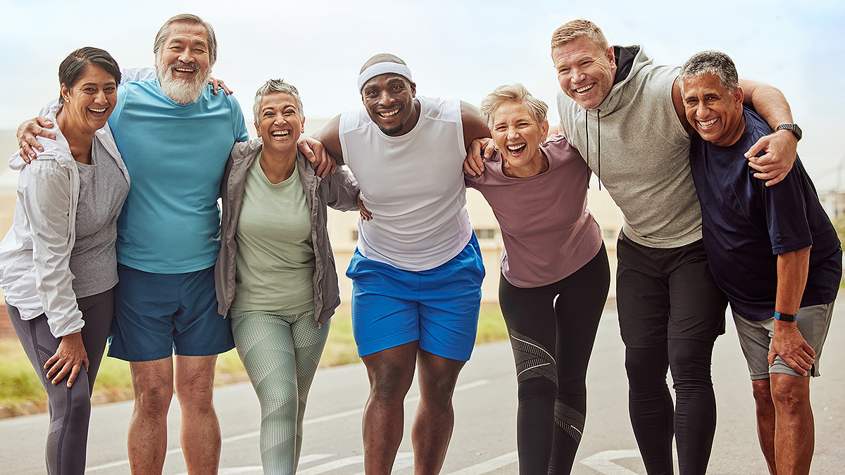 Diverse group of seven adults posing with arms around each other after a run.
